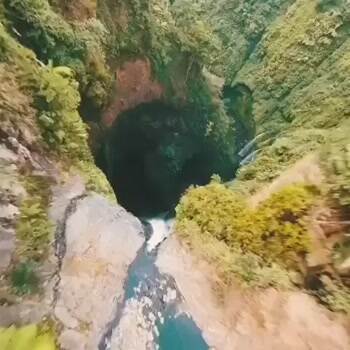 Incredible drone shot gliding down a waterfall